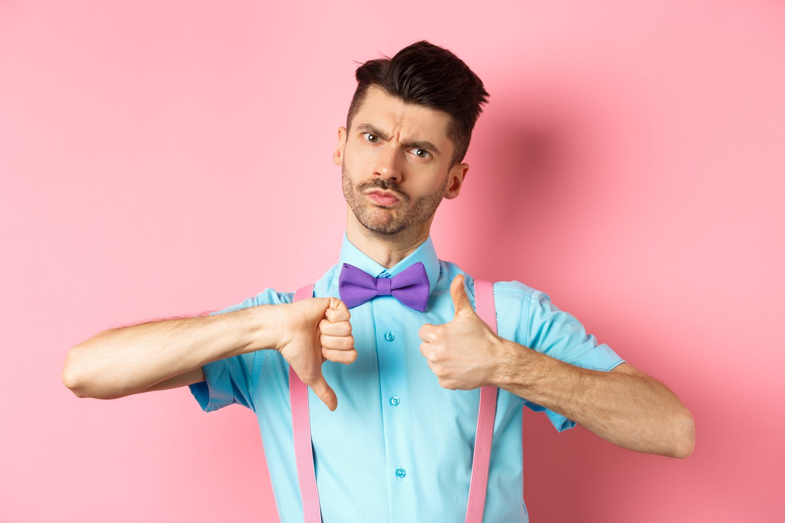 A man in a bow tie giving a thumbs up and a thumbs down, weighing up the best CV company in the UK
